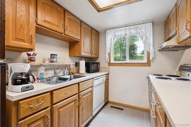 8552 Gray Ct, Arvada, CO 80003 - kitchen with under cabinet range hood, white appliances, a sink, light countertops, and baseboards