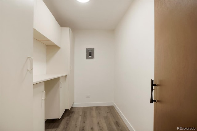 laundry room featuring light wood-type flooring and electric panel