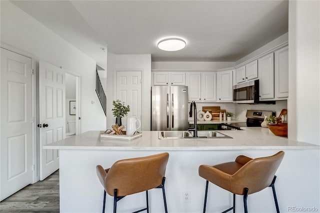 2642 Devonshire Ct, Denver, CO 80229 - kitchen with stainless steel appliances, a sink, a breakfast bar area, and light countertops