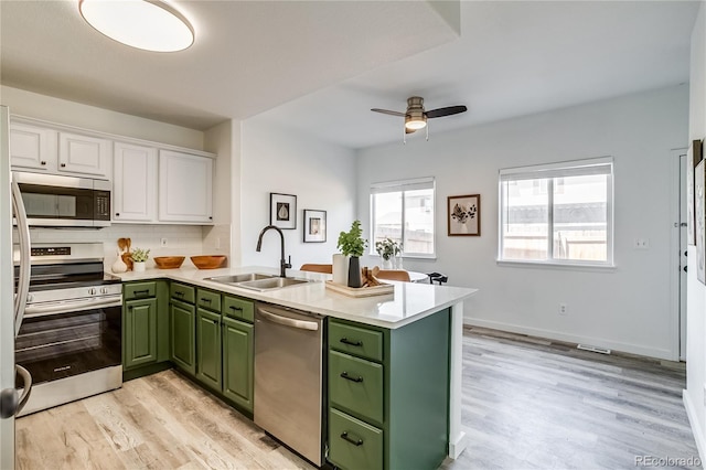 2642 Devonshire Ct, Denver, CO 80229 - kitchen with green cabinetry, stainless steel appliances, a peninsula, and a sink
