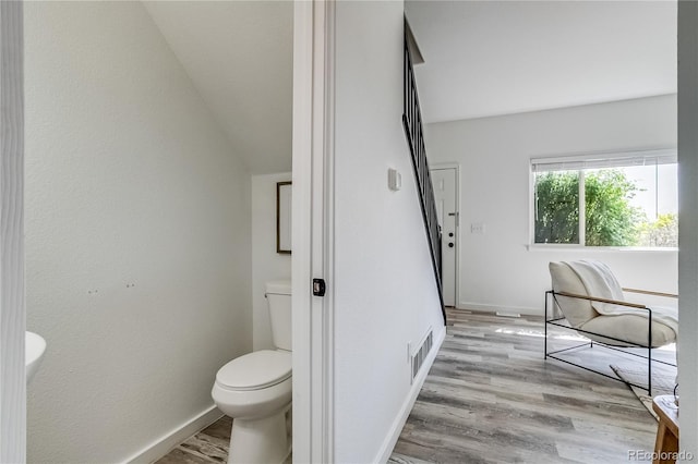 2642 Devonshire Ct, Denver, CO 80229 - bathroom featuring toilet, baseboards, wood finished floors, and lofted ceiling