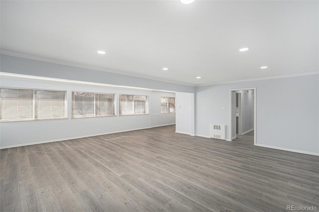 spare room with baseboards, ornamental molding, wood finished floors, and recessed lighting