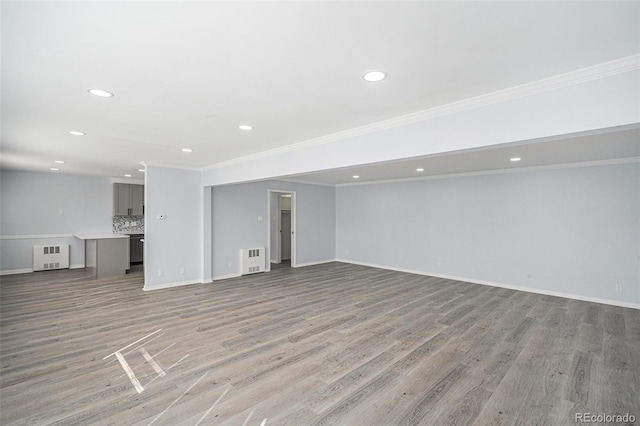 unfurnished living room with light wood-style floors, crown molding, and baseboards