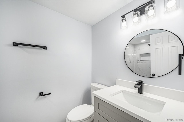 bathroom featuring toilet, a shower, and vanity