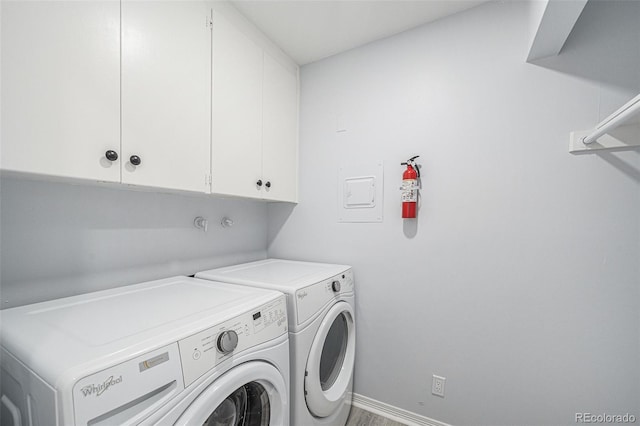 laundry area with washing machine and clothes dryer, cabinet space, and baseboards