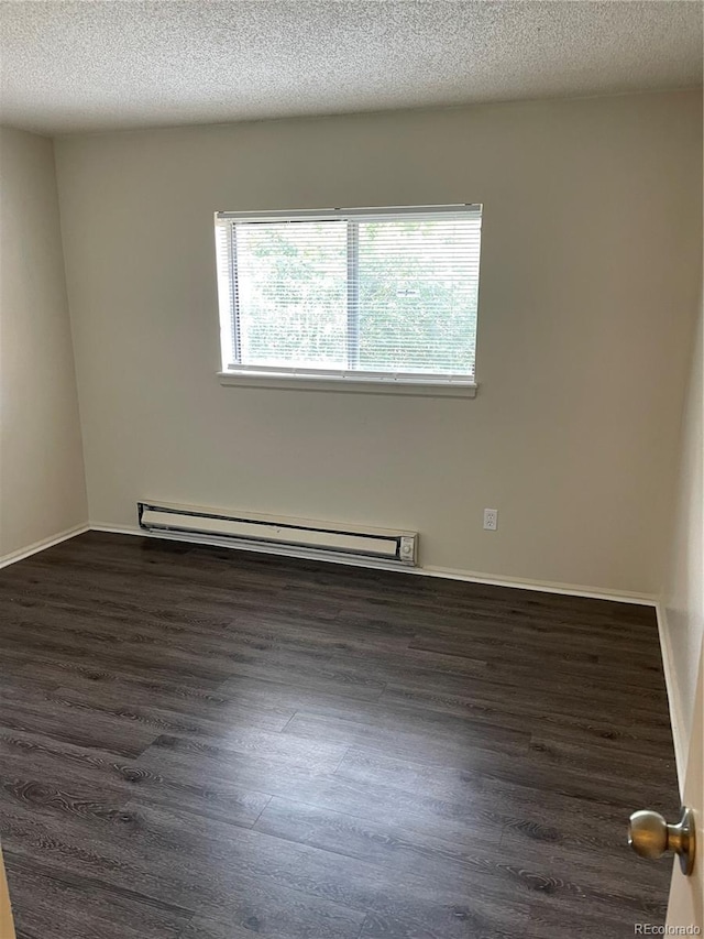14704 E 2nd Ave Unit 300E, Aurora, CO 80011 - unfurnished room featuring plenty of natural light, dark wood finished floors, a baseboard radiator, and a textured ceiling