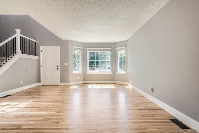 5370 S Jebel St, Centennial, CO 80015 - unfurnished living room featuring a textured ceiling, light wood-type flooring, and stairs