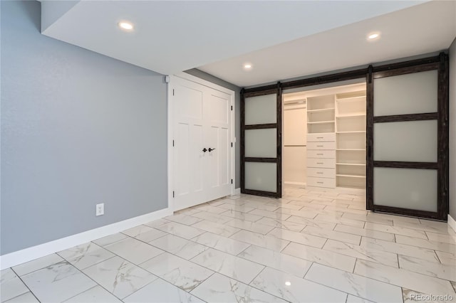5370 S Jebel St, Centennial, CO 80015 - empty room featuring a barn door, light marble finish flooring, and recessed lighting