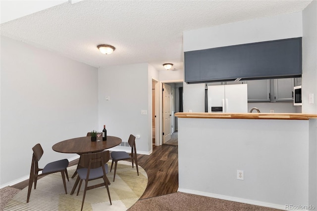 2973 W 81st Ave Unit D, Westminster, CO 80031 - dining space featuring dark wood-style flooring and a textured ceiling