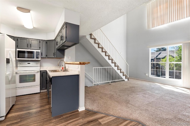 2973 W 81st Ave Unit D, Westminster, CO 80031 - kitchen with white appliances, light countertops, gray cabinetry, dark wood finished floors, and open floor plan