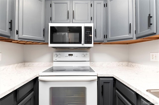 2973 W 81st Ave Unit D, Westminster, CO 80031 - kitchen with white electric stove, gray cabinetry, and light countertops