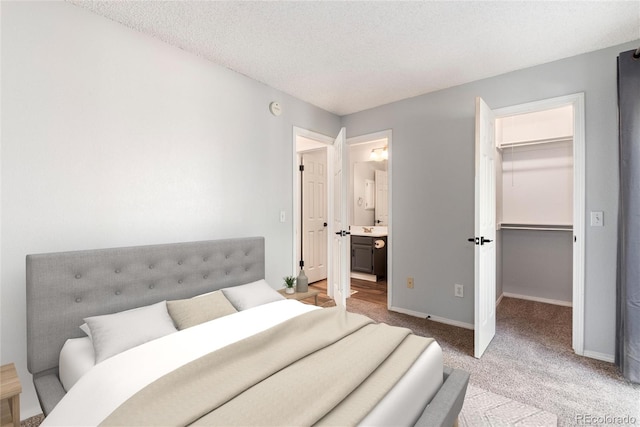 2973 W 81st Ave Unit D, Westminster, CO 80031 - bedroom featuring a spacious closet, light carpet, a textured ceiling, ensuite bathroom, and a closet