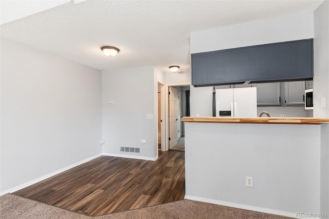 2973 W 81st Ave Unit D, Westminster, CO 80031 - kitchen featuring freestanding refrigerator, wood counters, dark wood-type flooring, a textured ceiling, and a peninsula