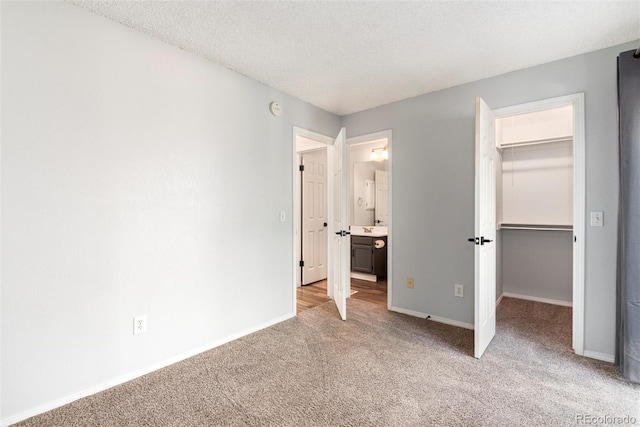2973 W 81st Ave Unit D, Westminster, CO 80031 - unfurnished bedroom featuring a spacious closet, light carpet, a closet, ensuite bath, and a textured ceiling