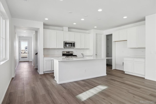 kitchen featuring white cabinets, appliances with stainless steel finishes, and a kitchen island with sink