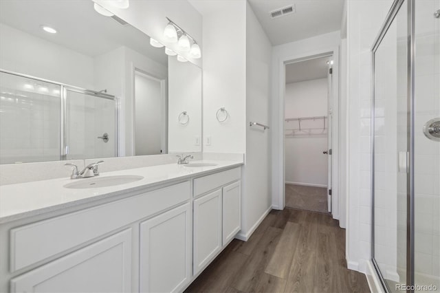 bathroom featuring vanity, wood-type flooring, and walk in shower