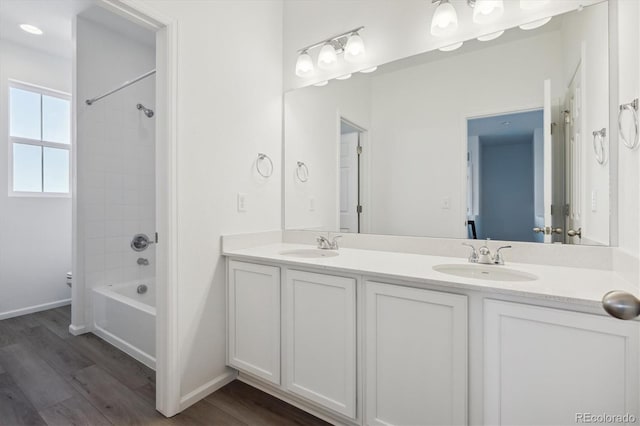 bathroom with vanity, hardwood / wood-style flooring, and tiled shower / bath