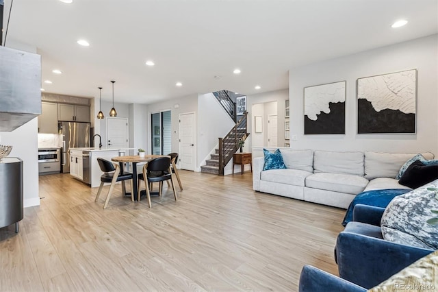 living room with recessed lighting, stairs, and light wood-style floors