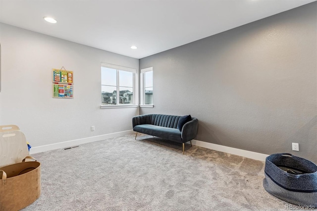 living area featuring baseboards, carpet, and visible vents