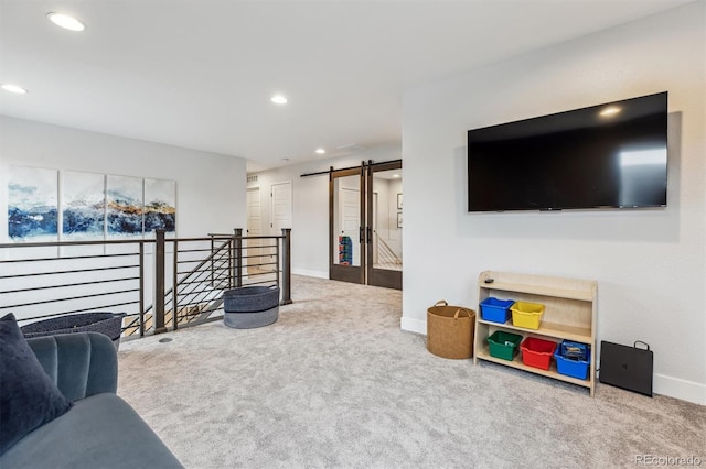 carpeted living room featuring baseboards, recessed lighting, and a barn door