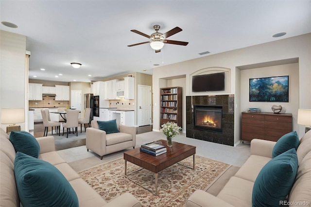 living room with ceiling fan and a fireplace