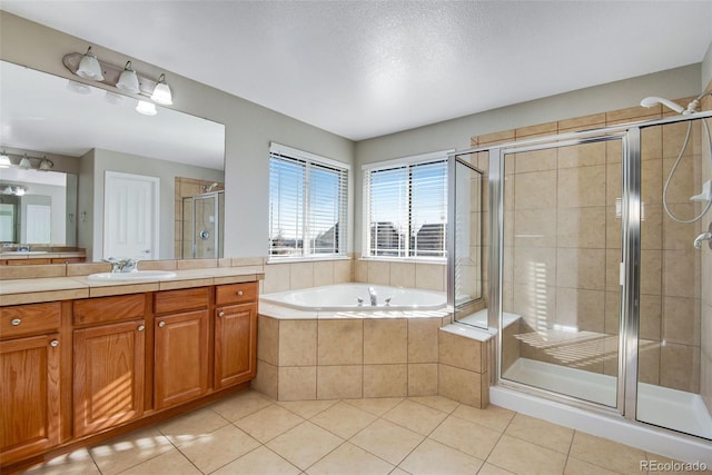 bathroom featuring tile patterned flooring, vanity, a textured ceiling, and shower with separate bathtub