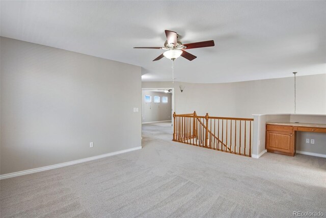 empty room featuring light colored carpet and ceiling fan