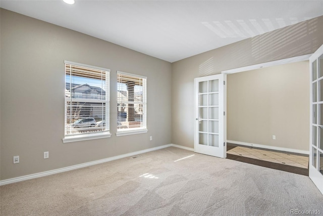 unfurnished room with french doors and light colored carpet