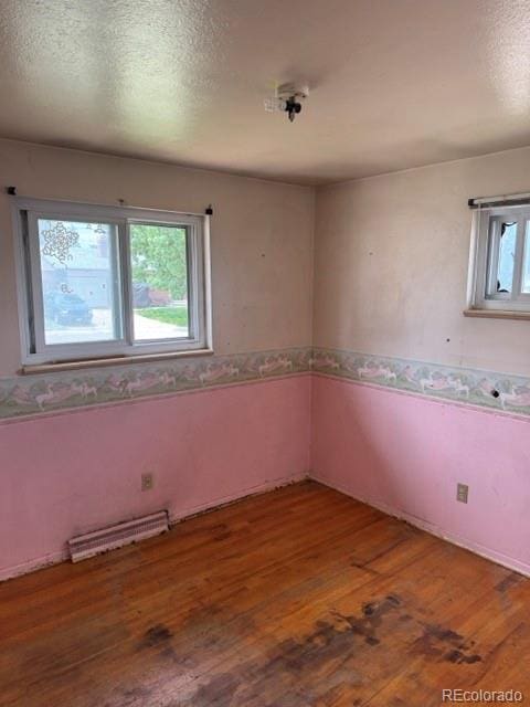 8250 Ralph Ln, Denver, CO 80221 - unfurnished room with hardwood / wood-style flooring, a wainscoted wall, and a textured ceiling