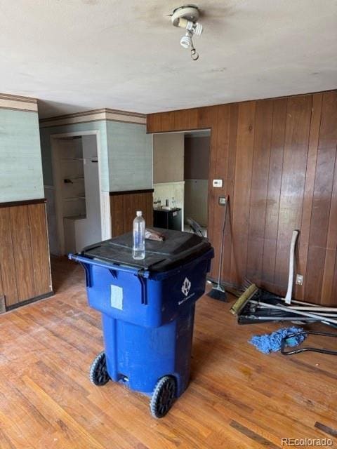 8250 Ralph Ln, Denver, CO 80221 - kitchen featuring wooden walls, light wood-style floors, a breakfast bar area, dark countertops, and a center island