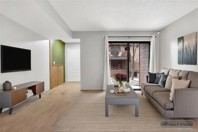 living area featuring light wood-type flooring and a textured ceiling