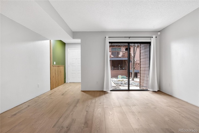 unfurnished room with light wood-style floors and a textured ceiling