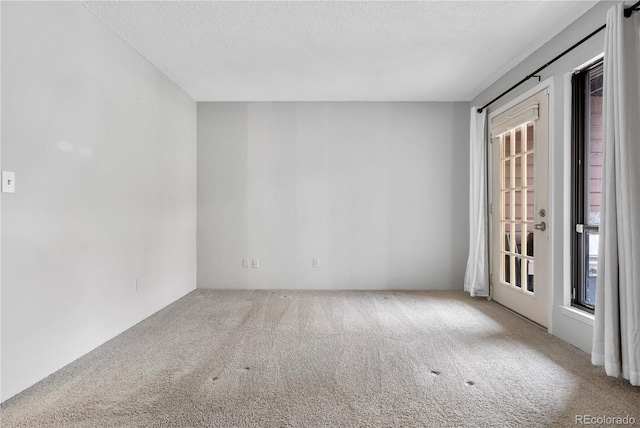 empty room with a textured ceiling and carpet floors