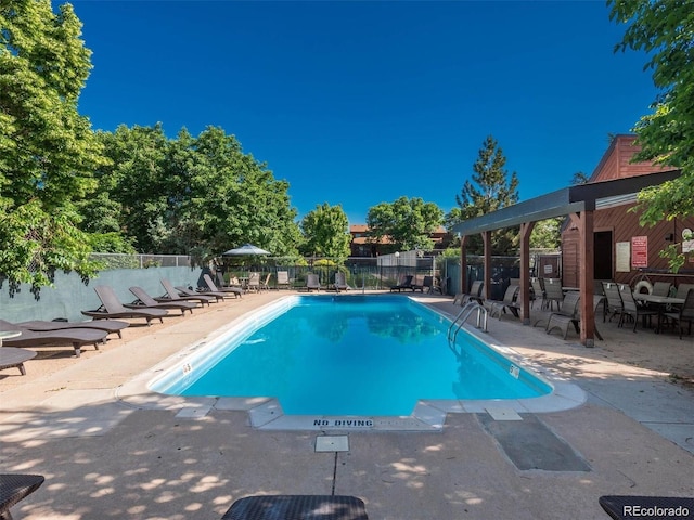 community pool featuring fence and a patio