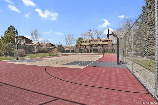 view of sport court featuring a tennis court, a residential view, community basketball court, and fence