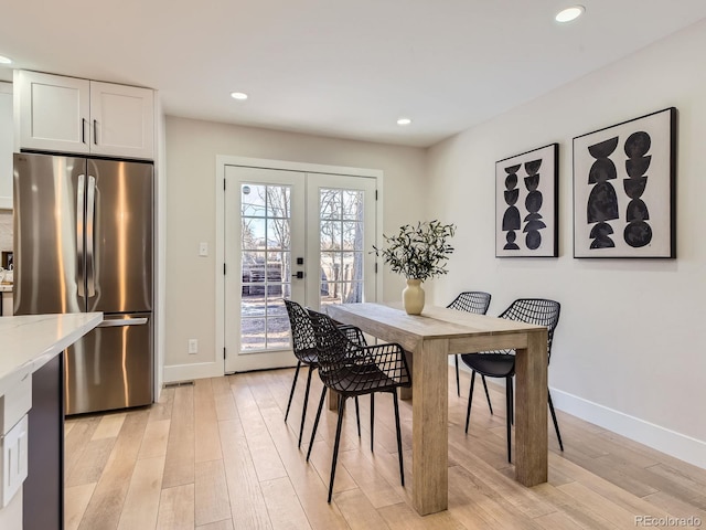 dining room featuring french doors and light hardwood / wood-style floors