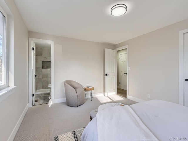 bedroom with ensuite bath and light carpet