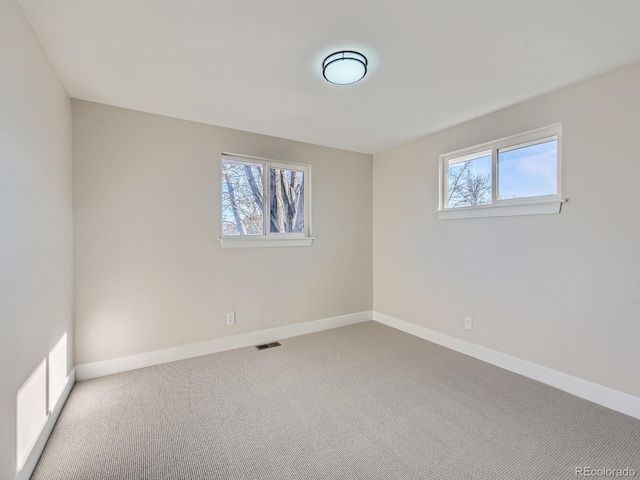 empty room with carpet floors and a wealth of natural light