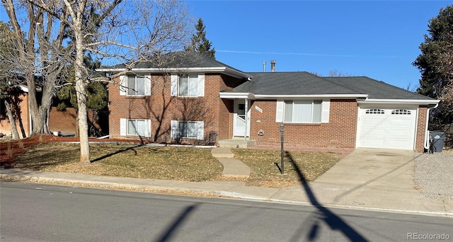 tri-level home featuring a front lawn and a garage