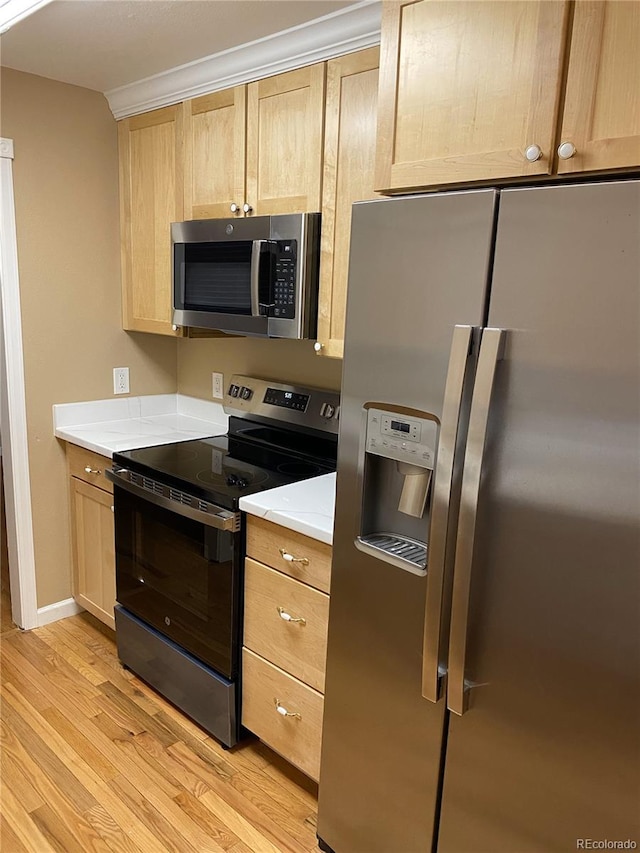 kitchen featuring stainless steel appliances, light hardwood / wood-style flooring, light brown cabinets, and ornamental molding