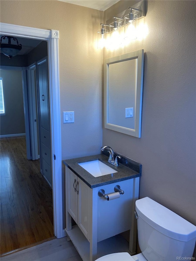 bathroom featuring toilet, hardwood / wood-style floors, and vanity