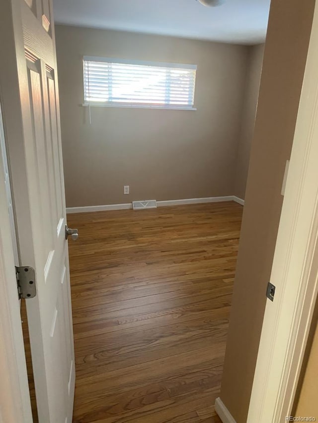 unfurnished room with a healthy amount of sunlight and wood-type flooring