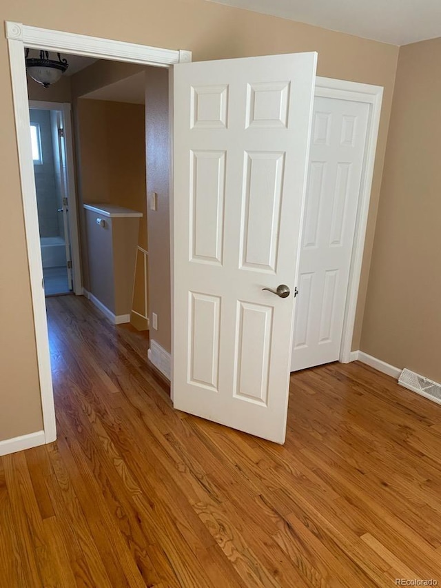 hall with hardwood / wood-style flooring