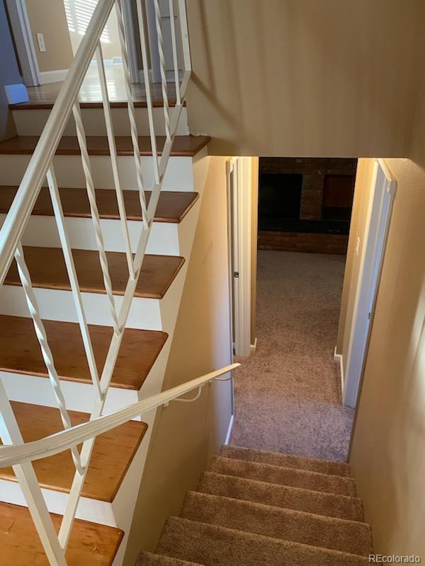 staircase featuring carpet floors and a fireplace