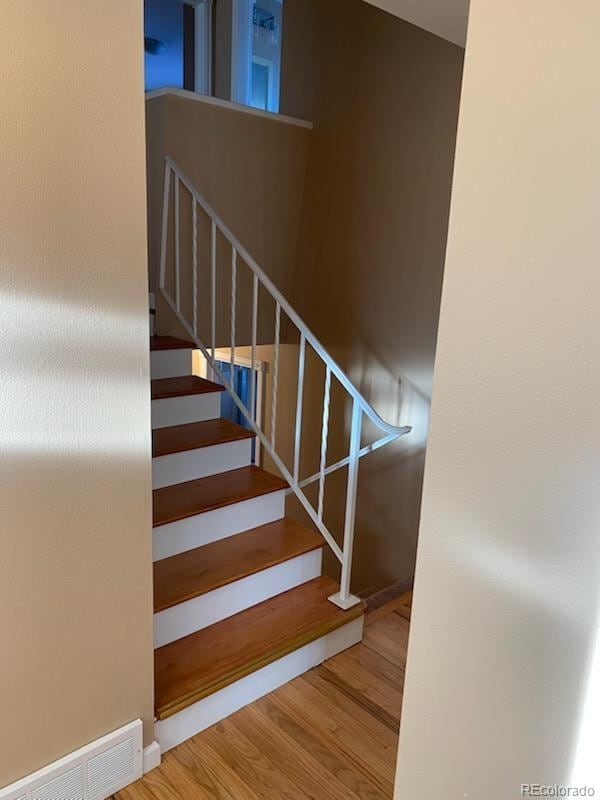 staircase with hardwood / wood-style floors