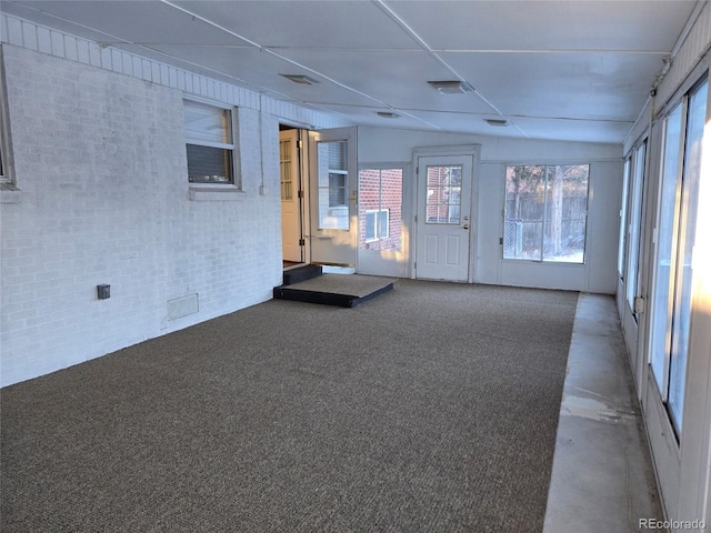 interior space with brick wall and carpet flooring