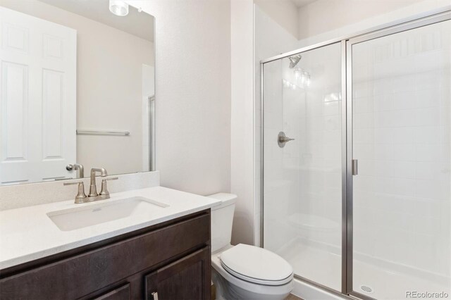 bathroom with vanity, toilet, and an enclosed shower