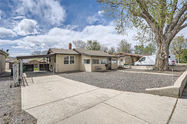 4835 Harlan St, Wheat Ridge, CO 80033 - back of property featuring concrete driveway, fence, an attached carport, and a chimney