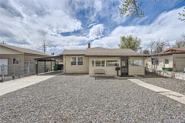 4835 Harlan St, Wheat Ridge, CO 80033 - rear view of property with concrete driveway, fence, a chimney, and a carport