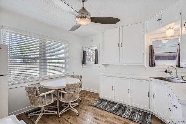 4835 Harlan St, Wheat Ridge, CO 80033 - kitchen with a sink, white cabinets, a ceiling fan, and wood-type flooring